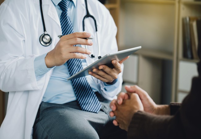 Psychiatrist inputting information from a patient in a digital tablet Psychiatrist inputting information from a patient in a digital tablet