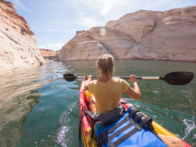 Rear view of woman canoeing inside canyon