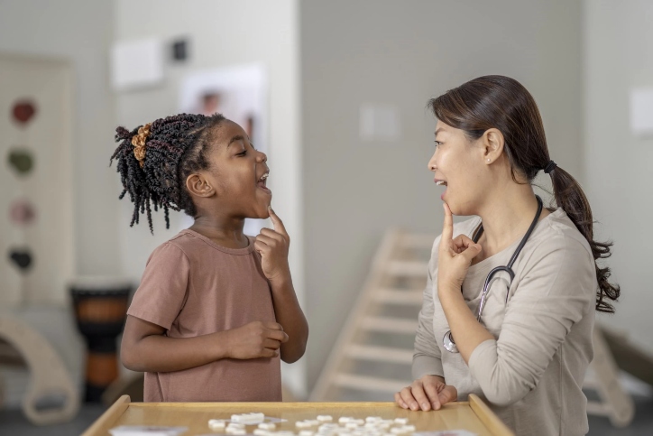 Therapist guiding young patient through speech therapy Therapist guiding young patient through speech therapy