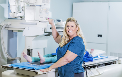 Rad tech smiling while working on a patient Rad tech smiling while working on a patient