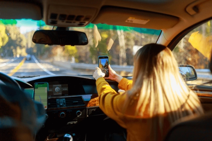 woman sitting in car with her cellphone woman sitting in car with her cellphone