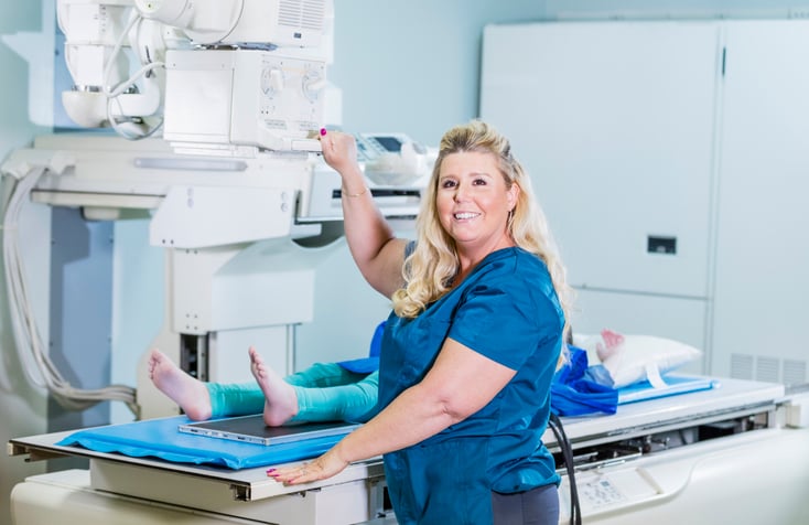 Rad tech smiling while working on a patient