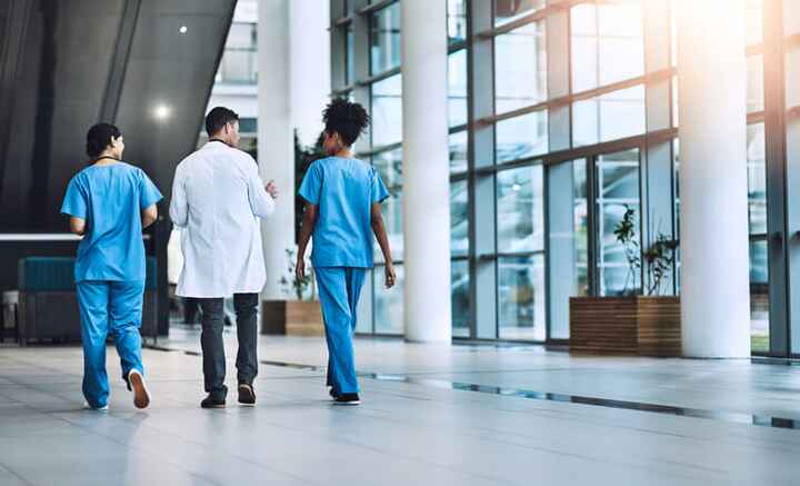 4 nurses walking down hallway