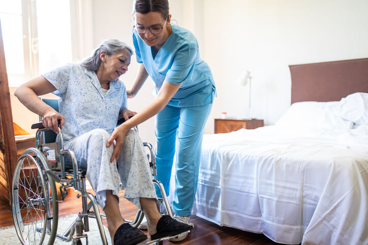 nurse helping patient with leg and wheelchair