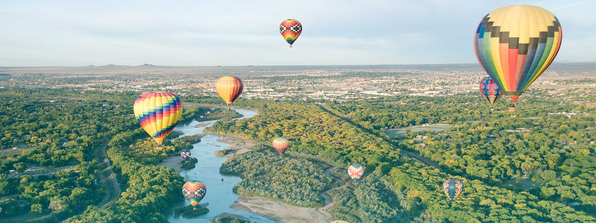 New Mexico hot air balloons in flight over a city