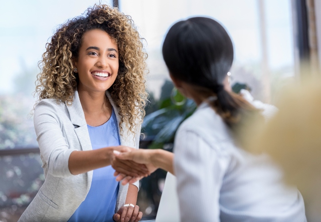 Business woman shaking hands with colleague