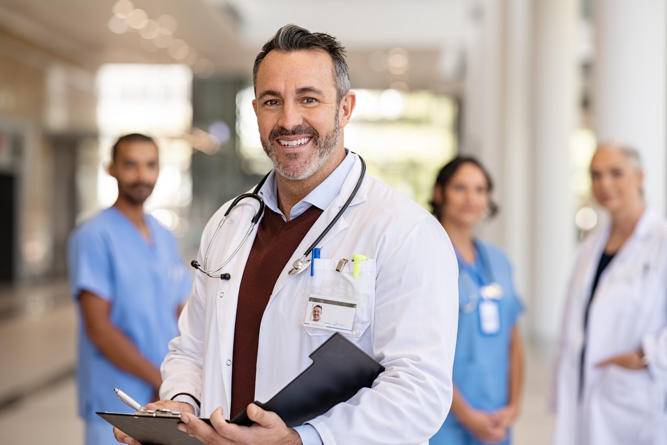 smiling doctor and supporting medical staff smiling doctor and supporting medical staff