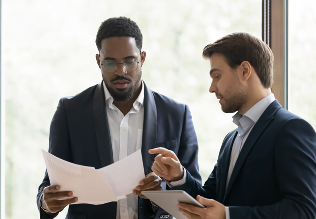 Two business men looking at business reports